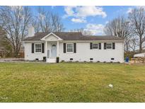Charming single-story home features a brick facade, manicured lawn, and classic architectural details at 407 Westgate Dr, Elon, NC 27244