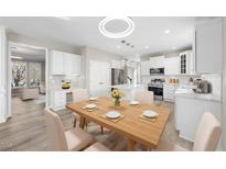 Bright eat-in kitchen features white cabinets, stainless appliances, and modern lighting at 4703 Paces Ferry Dr, Durham, NC 27712
