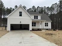Charming two-story home with attached garage, light siding, and newly seeded front lawn at 50 Arbor Dr, Youngsville, NC 27596