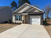 Charming single-story home featuring a brick-accented garage and newly installed landscaping at 394 Maidenhair Pl, Clayton, NC 27520