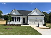Charming new construction home featuring white siding, black shutters, and a two-car garage at 45 Mossman Ct, Zebulon, NC 27597