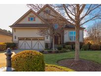 Two-story house with a stone and shingle exterior, two-car garage, and manicured lawn at 7845 Hasentree Lake Dr, Wake Forest, NC 27587