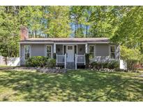 Charming home featuring a manicured front yard and a cozy front porch at 1304 Rothes Rd, Cary, NC 27511