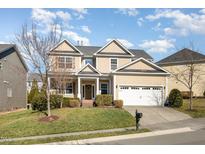 Charming two-story home with a manicured lawn, attached garage, and inviting curb appeal at 218 Strolling Way, Durham, NC 27707