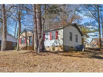 Charming single-story home with mature trees, brick accents, red shutters and a well-manicured lawn at 2400 Keith Dr, Raleigh, NC 27610