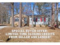 Charming single-story home featuring a brick facade, bright red shutters, and mature trees at 2400 Keith Dr, Raleigh, NC 27610