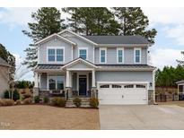 Two-story home with gray siding, white garage door, and landscaping at 3048 Curling Creek Dr, Apex, NC 27502