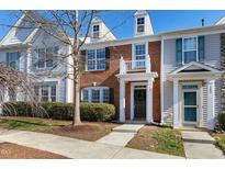 Charming townhome with brick and siding exterior, a small porch, and well-kept landscaping at 307 Walnut Woods Dr, Morrisville, NC 27560