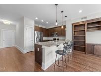 Modern kitchen featuring stainless steel appliances, granite countertops, and a breakfast bar with pendant lighting at 700 Finsbury St # 105, Durham, NC 27703