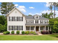 Charming two-story white brick home with black shutters, a covered porch, and a beautifully landscaped lawn at 1141 Barley Stone Way, Raleigh, NC 27603