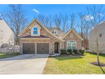 Two-story house with stone and siding accents, two-car garage, and landscaped lawn at 2242 Colorado Dr, Graham, NC 27253