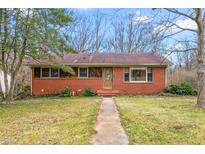 Brick ranch house with a landscaped lawn and walkway at 2581 Hyde St, Burlington, NC 27217