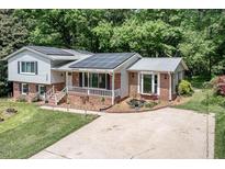 Charming brick home with solar panels, manicured lawn and flower beds at 326 W Bywood Dr, Durham, NC 27712