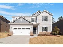 Two-story home with gray siding, white garage door, and landscaped lawn at 3534 Lovage Dr, Apex, NC 27502