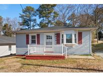 Ranch style home with red shutters, front porch, and brick steps at 3817 Booker Ave, Durham, NC 27713