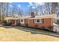Brick ranch house with mature landscaping and a spacious lawn at 420 Nelson St, Durham, NC 27707
