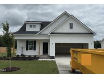 New construction home with white siding, attached garage, and newly seeded front yard at 59 Pretty Run Branch Ln, Wendell, NC 27591
