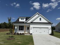 Charming new construction home with a two-car garage, well-manicured lawn, and inviting front porch at 59 Pretty Run Branch Ln, Wendell, NC 27591