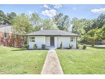 Charming white brick ranch house with a well-manicured lawn at 713 Hudson Ave, Durham, NC 27704