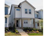 Charming two-story home featuring board and batten siding, brick accents, and a welcoming front porch at 930 Allen Pk Dr, Raleigh, NC 27604
