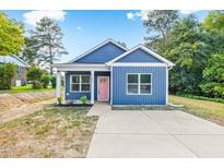 Charming home with blue siding, white trim, pink front door, and a concrete driveway at 0 Cedar Grove Church Rd Rd, Roxboro, NC 27574