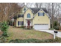 Beautiful two-story yellow house with a large yard and two-car garage at 102 Wightman Ct, Cary, NC 27511