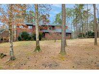 Charming brown two-story home nestled among mature trees on a spacious lot at 11708 Appaloosa Run E, Raleigh, NC 27613