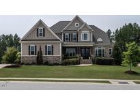 Beautiful two-story home featuring a manicured lawn, stone accents, and a welcoming front porch at 1509 Yardley Dr, Wake Forest, NC 27587