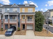 Two-story townhome with brick and siding exterior, attached garage, and front yard at 220 Broadgait Brae Rd, Cary, NC 27519
