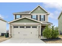 Charming two-story home with a two-car garage and manicured landscaping at 245 E Webber Ln, Clayton, NC 27527