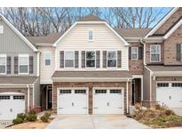 Two-story townhome with beige vinyl siding, two-car garage, and landscaping at 505 Great Eno Path, Hillsborough, NC 27278