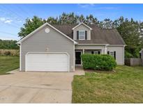 Charming single-Gathering home featuring a two-car garage, gray siding, and manicured lawn under a blue sky at 5110 Chipstone Dr, Raleigh, NC 27610