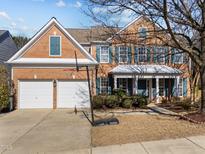 Charming brick home featuring a two-car garage, manicured lawn and a basketball hoop on the driveway at 5430 Wind Mountain Ln, Raleigh, NC 27613