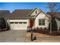 Charming single-story home boasts a two-car garage, bright red front door, and manicured landscaping at 66 Copper Lantern Dr, Chapel Hill, NC 27516
