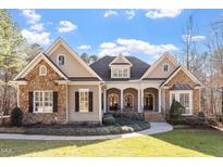 Charming home featuring stone and siding exterior, complemented by a well-manicured front yard and inviting entrance at 10014 Hammock Bend Bnd, Chapel Hill, NC 27517