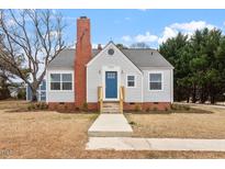 Charming bungalow-style home featuring a brick chimney and a welcoming blue front door at 2001 Rolesville Rd, Wake Forest, NC 27587