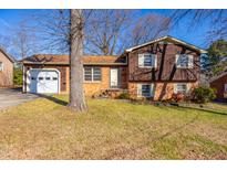 Charming two-story home with brick and wood siding, attached garage and a well-manicured front lawn at 206 Eastway Ln, Graham, NC 27253