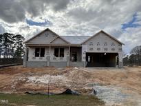 New home under construction features an attached garage and a covered front porch at 221 Tee Dr, Selma, NC 27576