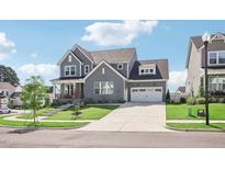 Charming two-story home with brick, siding, manicured lawn, and attached two car garage at 236 Artisan Park Dr, Wake Forest, NC 27587