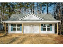 Charming single-story home with covered porch, blue shutters, and freshly landscaped yard at 2484 Michelle Dr, Burlington, NC 27217