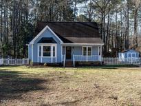 Charming blue home with a picket fence and a well-maintained yard at 2555 N Shiloh Rd, Garner, NC 27529