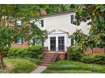 Charming exterior of a multi-level home showcasing brick steps, a covered entryway, and beautiful surrounding greenery at 3929 Browning Pl, Raleigh, NC 27609