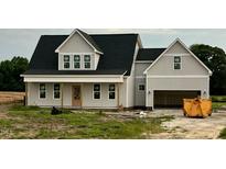 Newly constructed two-story home featuring a two-car garage and charming front porch at 3943 Baileys Xrds Rd, Benson, NC 27504
