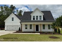 Charming two-story home featuring a welcoming front porch, attached two-car garage, and a well-manicured lawn at 3943 Baileys Xrds Rd, Benson, NC 27504