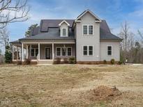 Charming two-story home with gray siding, covered porch, solar panels, and a spacious front yard at 3958 Buckhorn Rd, Sanford, NC 27330