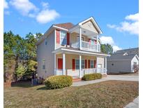 Charming two-story home featuring a double-decker porch with red shutters at 5841 Wynmore Rd, Raleigh, NC 27610