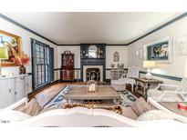 Cozy living room with a fireplace, hardwood floors and elegant decor perfect for relaxing and entertaining at 612 W Chisholm St, Sanford, NC 27330