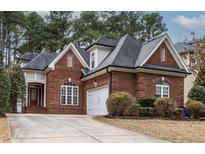 Charming brick home featuring a well-manicured lawn, driveway and a two-car garage at 7373 Newport Ave, Raleigh, NC 27613
