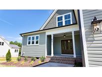Charming home featuring a covered front entrance with craftsman details, a brick landing, and verdant landscaping at 83 Nottoway Lane, Wendell, NC 27591