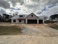 A charming exterior view of a new home under construction with an attached two-car garage and a dormer window at 87 Tee Dr, Selma, NC 27576